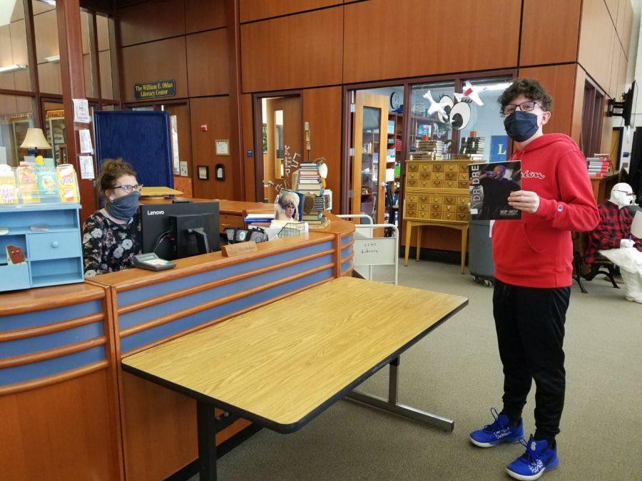 Freshman Alex Eurek checks out a book from the library. Photo by Valerie Egger.