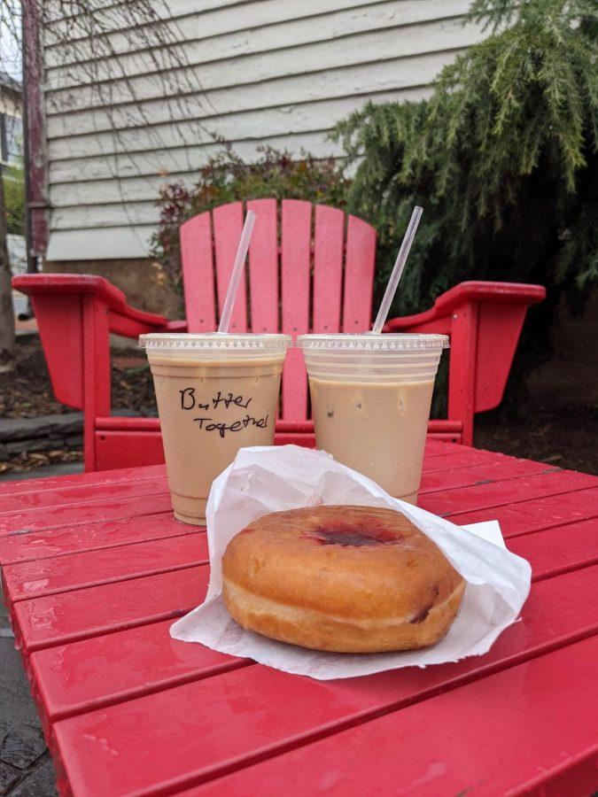 1.	An iced coffee, as well as a coffee recipe unique to King Street Coffee known as the “Butter Together” and a jelly donut from their small bakery are pictured on a set in a small outdoor eating area in the space behind the shop. Photo by Liberty Harrison. 
