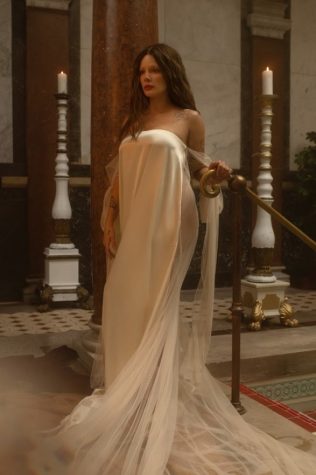 Halsey wears a white dress in the two-minute video that was used to promote her new album “If I Can’t Have Love, I Want Power”. She walks through a museum while admiring a portrait of herself that is used as her album cover. 
