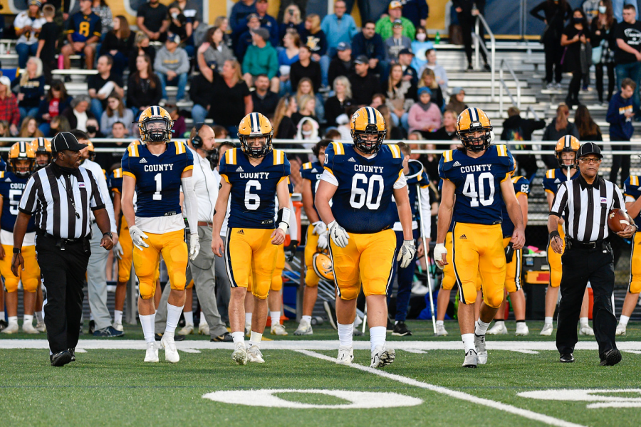The Captain leaders #1 Jimmy Kibble, #63 Evan Stanley, #40 Jack Snyder, and #26 Matt Jackmore approaches the logo at the fifty yard line for the coin toss, prior to their first home game since 2019. Picture Credits: https://jklimphotos.smugmug.com/Sports/LCHS-2021/2021-VAR-Football-Tuscarora-Huskies/i-GXj4psj/A 