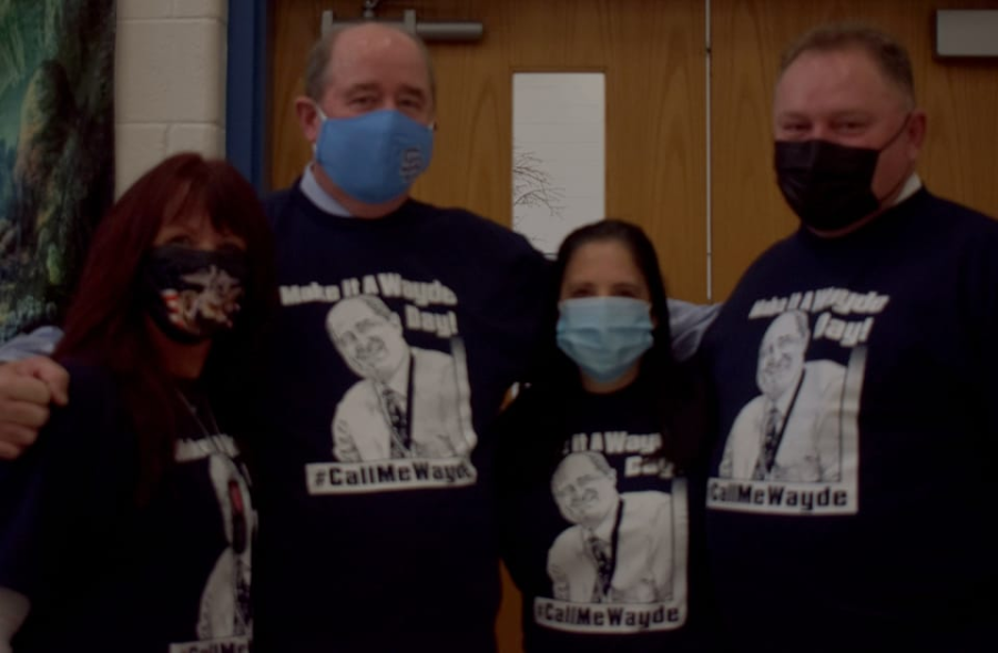 Wayde Byard poses with the Stone Bridge High school staff dressed in Byard merchandise. Teacher Faith Ibarra asked Byard for permission to put his face on the merchandise, and Byard made the counter proposal of having a photo shoot in it. Photo Courtesy of Faith Ibarra
