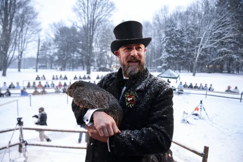 AJ Dereume, groundhog handler, holds Punxsutawney Phil at Gobbler’s Knob on Groundhog Day. Phil predicted six more weeks of winter again this year. Photo credit Barry Reeger, AP, via The Philadelphia Inquirer.