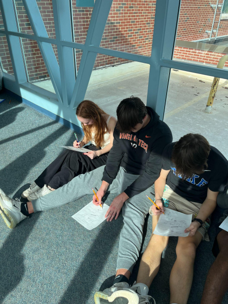 

Juniors Kira Schneider, Chase Kibble, and Connor Williams worked together as a group to solve math problems on the glass bridge during math class. Photo by Tae Herron.