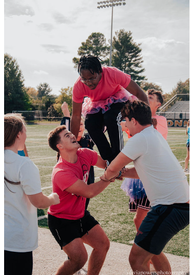 Jacob Luizer and Luke Yeager perform a cheer stunt with Tae Herron as the flier. 10/12/22. Photo courtesy of Olivia Powers.