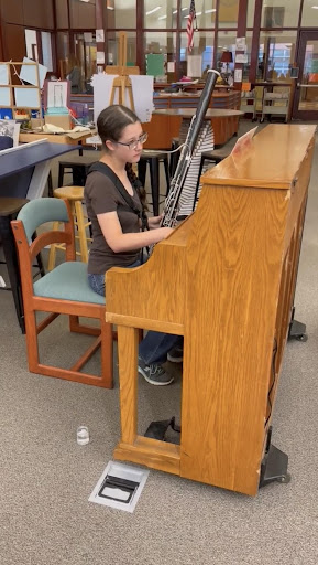 Emily Banner plays both the bassoon and the piano for P.D.Q. Bach’s “Sonata Abassoonata at the same time during a faculty meeting. Banner had principal Michelle Luttrell play along with the piece’s satirical theme by announcing that the pianist was unavailable and Banner would be playing both parts.