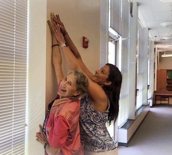 Principal Michelle Luttrell assists now-retired science teacher, Felicity Francis, as she adds her handprint to the top of the new “It Takes a Village” handprint wall. Francis became the first person to have the opportunity to add their handprint to the influential wall as of June 2022. Photo Courtesy of Michelle Luttrell.