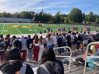 Students of all grade levels fill the stands at the Power Buff game. All around you can hear students cheering as the announcer narrates the game. 