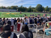 Students of all grade levels fill the stands at the Power Buff game. All around you can hear students cheering as the announcer narrates the game.