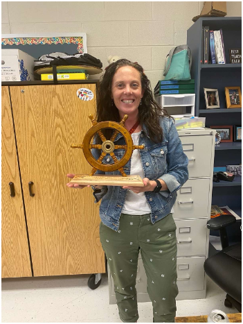 Math teacher Abby Schutte smiles for the camera, trophy in hand, holding her Teacher of the Month award. The award is voted upon by students to be given to teachers that show excellence in teaching and contribute to making our school a better place. Schutte won Teacher of the Month this past September.