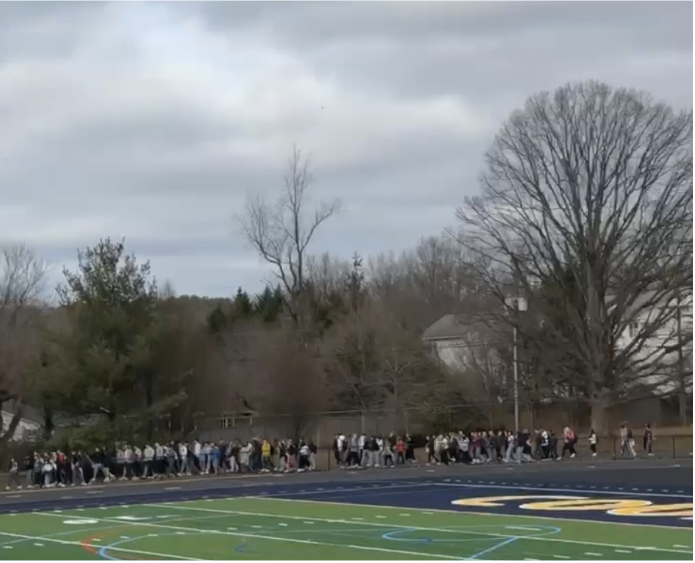 Students enter the football stadium to evacuate the school building. The evacuation was caused by a gas leak in the school, and all students and staff were asked to quickly leave the school building and go to the bleachers in the stadium outside.