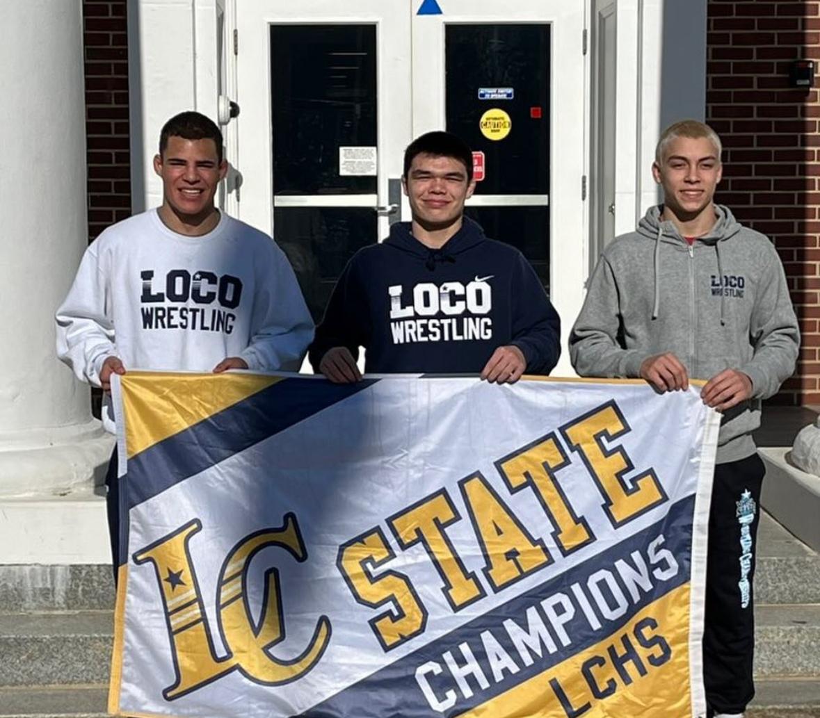 From left to right: Senior Octavian Ashford, sophomore Justin Lowery, and sophomore Lincoln Kelley display the Loudoun County State Champions banner after earning gold in their respective wrestling categories. 