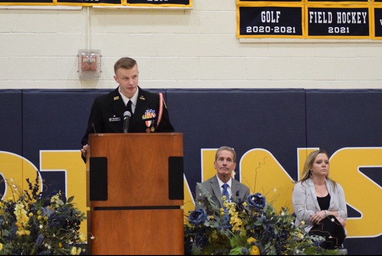 Ryan Colavita (left) honors veterans in a heartfelt speech, while guest speaker Steven Vahsen (middle) and assistant principal Katie Post (right) look up at the stage. Photo by Romesa Mazhar
