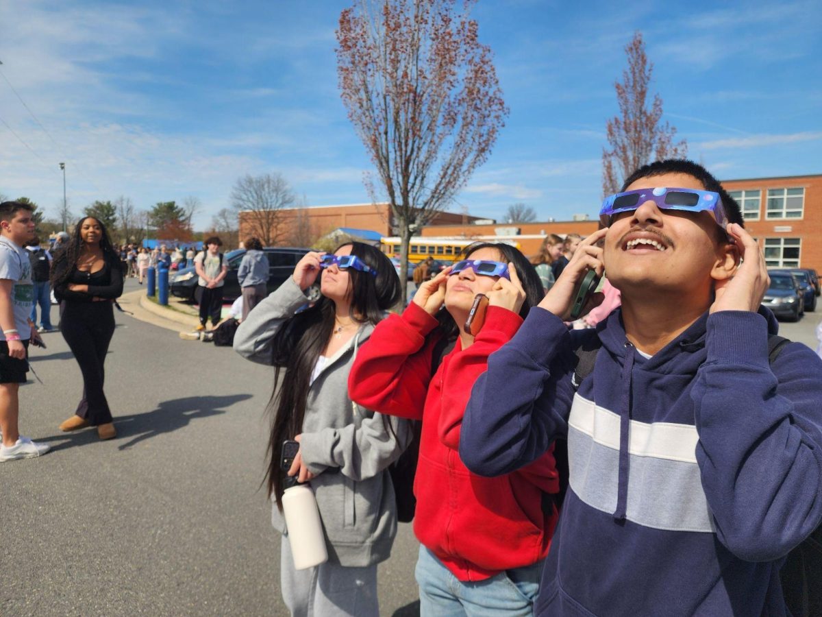 (From right to left) Sophomores Karan Singh, Melanie Sanchez, Isabela Sitcharing watching the eclipse. Photo by Valerie Egger.