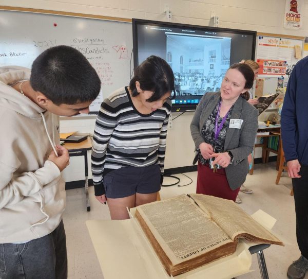 Left to right: Sophomore Karan Singh, senior Brianna Martinez, and Curator of Manuscripts and Archives, Laura Christiansen, look over a collection of 19th century newspapers. Martinez gasps at the sight of an ad for a person for sale. 