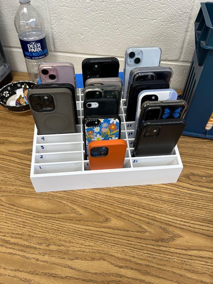 Students place their phones in the provided holder for the class period. According to the policy, students are not allowed to retrieve their phones until the dismissal bell rings. 