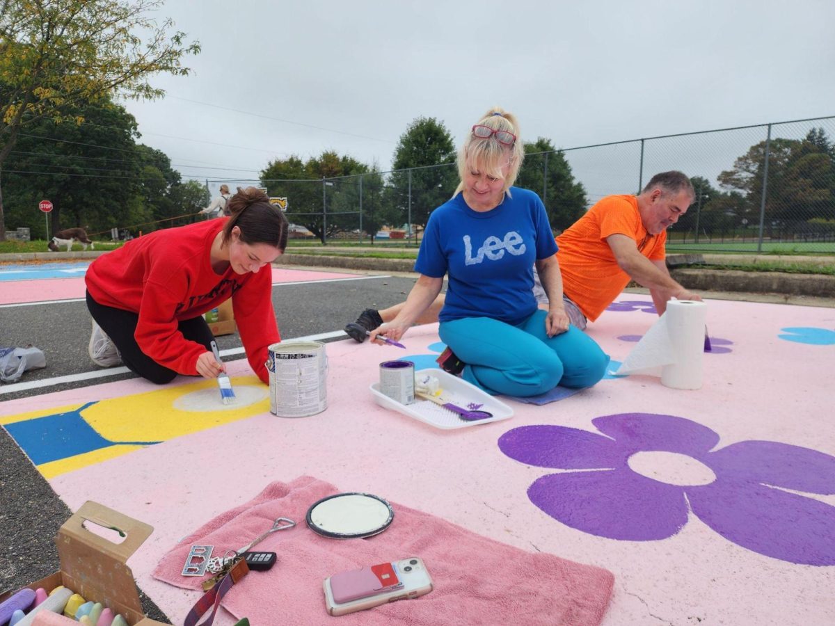 Senior Lexie Pantas and her parents paint Pantas’s parking spot dur -ing a teacher workday in October. “A lot of people were excited because some people have had ideas of what they wanted to paint since fresh -man year, ” Pantas said. “Allowing them to paint their parking spots adds a vibrancy and a personality to the school and it makes the school more alive and fun, ” Karen Pantas said while helping daughter Lexie paint her spot. Photo by Valerie Egger.