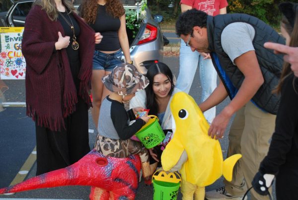 Junior Nalin Thongdygnarath hands out candy for trunk or treaters. Trunk or treaters went from each club's trunk to receive candy and rewards.