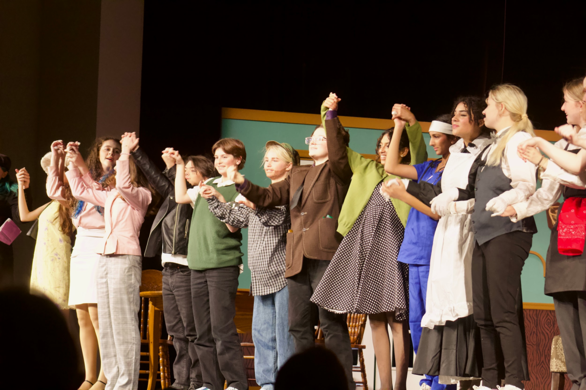 Cast members (L to R), including senior Frey Williams, sophomore Grace Allred, freshman Sami Pearson, junior Nate Wolf, sophomore Eli Kaywork, sophomore Emma Barts, junior Carson Phillips, senior Amaris Paranjattu, freshman Milania Ruparelia, junior Keira Pulley, and senior Jamie-Faye McKnight take a bow on the first night of the show in addition to commemorating crew members working behind the scenes. Photo by Taylor Helfer.