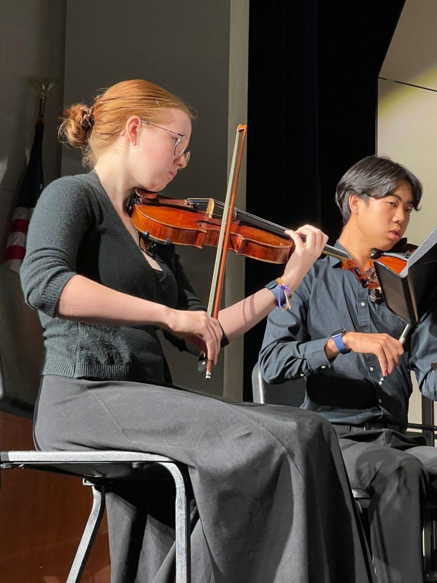 Seniors Felicity Banner and Pierson Lee perform on stage. Both Banner and Lee were asked to play music as part of the string quartet for the choir concert on December 12, 2024.