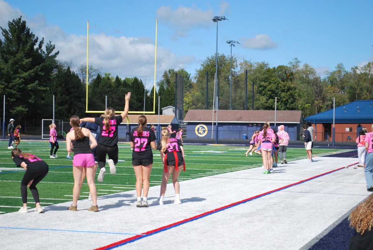 The junior team stands on the sidelines, cheering as their team scores a touchdown early in the game. Spirits were high on both sides and results were decided by a match of rock, paper, scissors with the juniors winning.