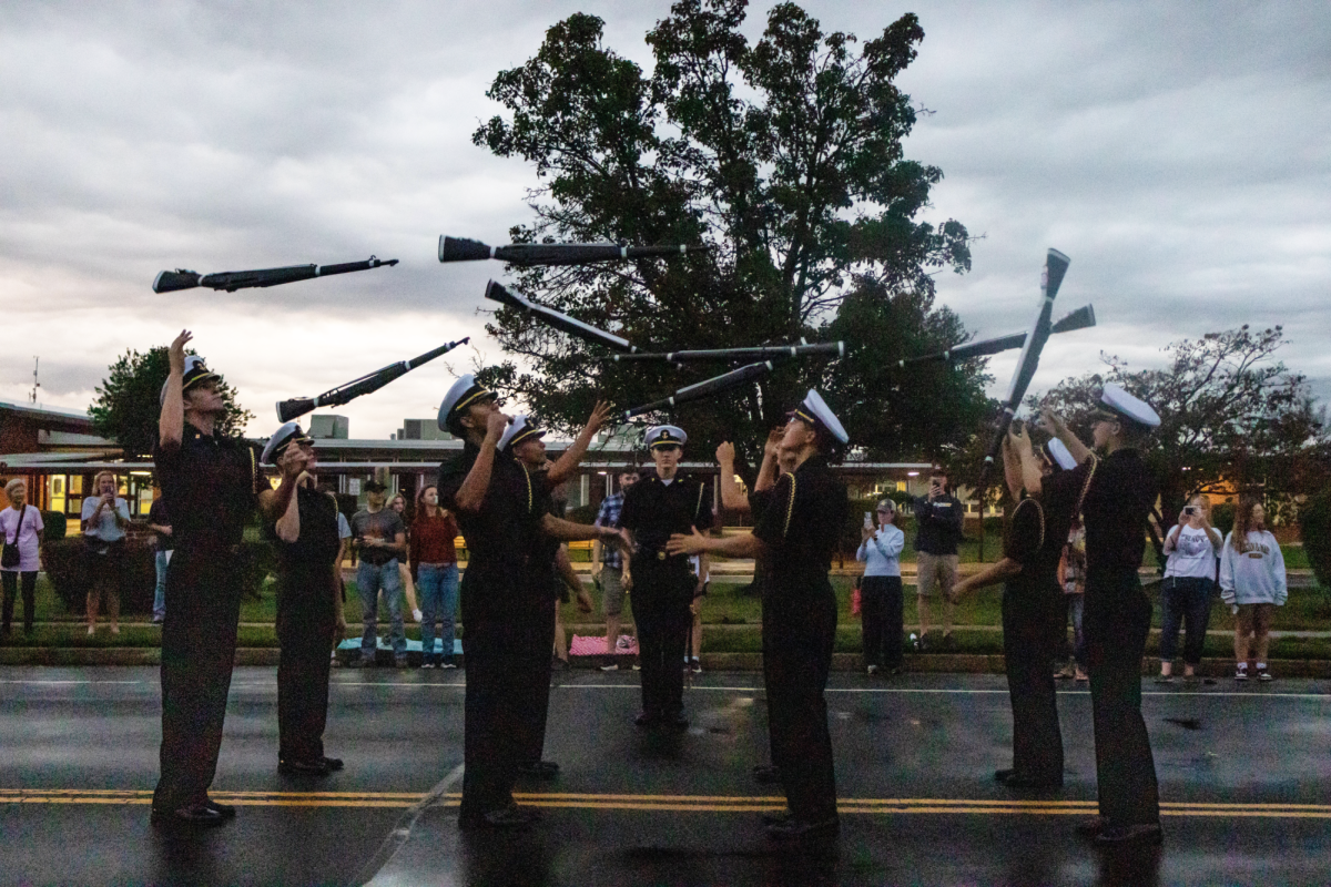 (Left to right) Junior Connor Colavita, senior Tucker Boos, junior Jordan Bruce, senior Logan Deladurantaye, senior Connor Quinn, senior Ben Lierni, senior Andrew Massey, senior Erik Buer, senior Justin Johnston, members of the NJROTC Armed Exhibition, throw their drill rifles as part of their routine. The Armed Exhibition was one of many student organizations that had to wait out the rain in Safeway. 
