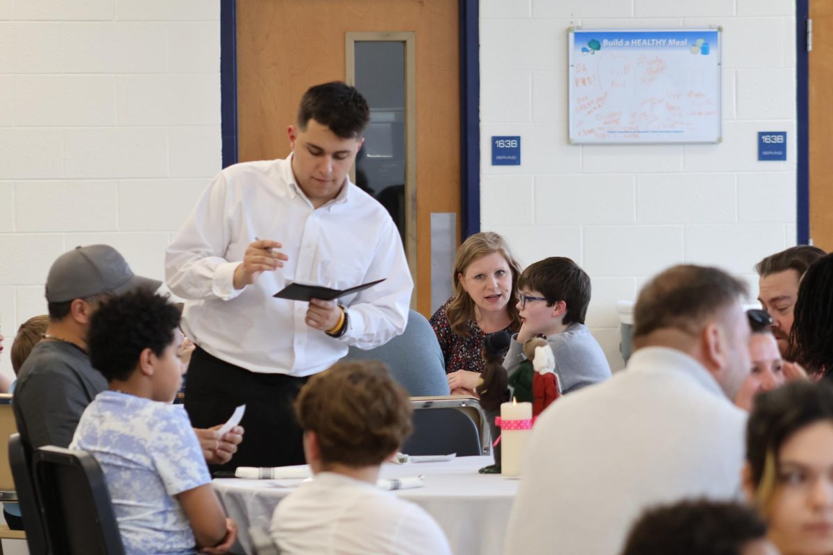 Junior Justin Goodhart takes a customer’s order. The meal was free for everyone attending the event. Artwork from students at Frederick Douglass Elementary School and J. Lupton Simpson Middle School was also on display at the event.