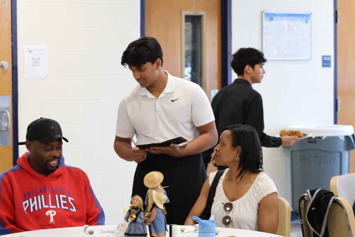 Junior Jaishua Manalel takes a guest’s drink order. “Everybody had a lot of food and a good time,” he said.